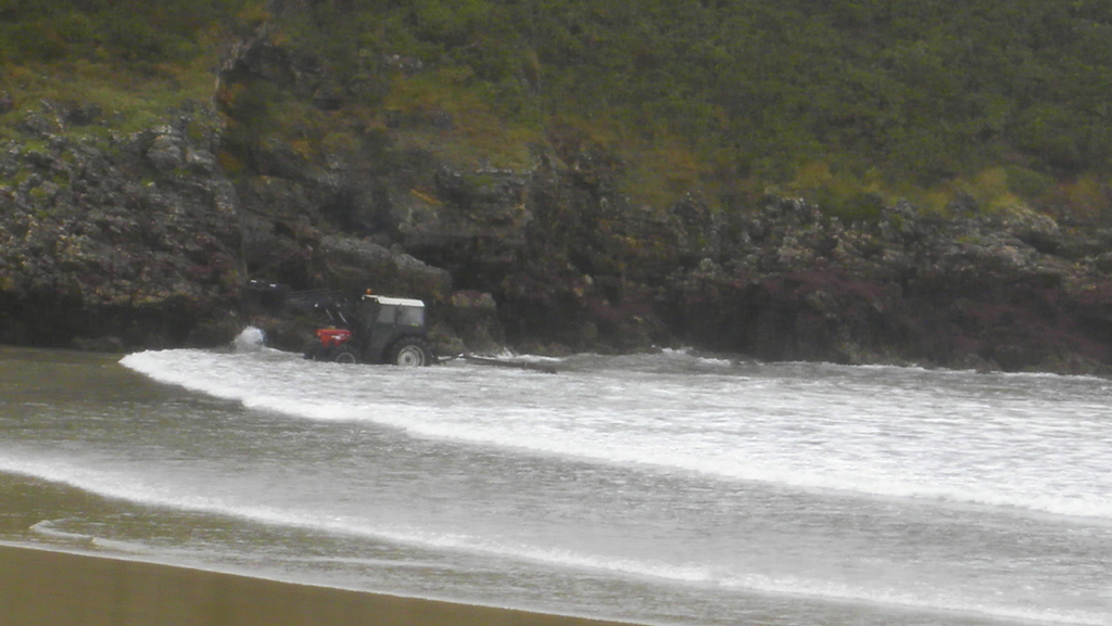 Unos recolectores de ocle se adentran en el agua con el tractor en Barro hace unos días - Celoriu.com